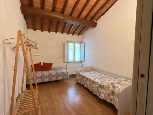 a room with two beds and a wooden ceiling at Appartamento Podere la Chiusa in Sesto Fiorentino