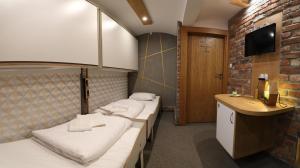 een hotelkamer met drie bedden en een televisie bij Pokoje Wieliczka in Wieliczka