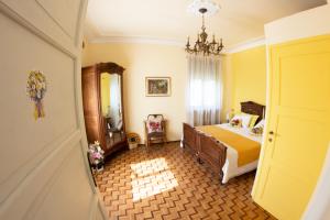 1 dormitorio con cama y lámpara de araña en Villa Delbia - L'Elfo, en Candelo