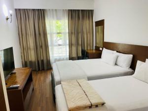 a hotel room with two beds and a television at EE HOTEL Johor Jaya in Johor Bahru