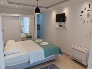 a white bedroom with a bed and a tv at Apartments Nancy in Kotor