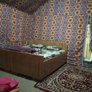 Cama pequeña en habitación con paredes coloridas y moqueta en Snow View Himalayan Adventure, en Kasol