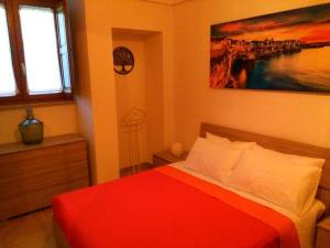 a bedroom with a red bed and a painting on the wall at DonVito Casa Vacanze in Alberobello