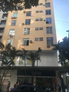un edificio alto con palmeras delante en Fantástico STUDIO DIVISA COPACABANA IPANEMA REFORMADO E DECORADO, en Río de Janeiro