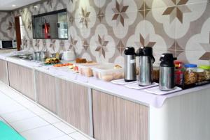 a buffet line in a kitchen with food on it at Hotel Nacional in Arapiraca +15 photos