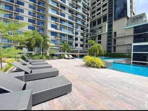 an apartment patio with lounge chairs and a swimming pool at Midtown Cebu City Condo in Cebu City