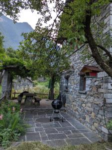 a grill sitting in front of a stone building at Rustico Tello in Linescio