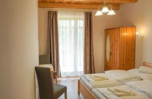 1 dormitorio con 2 camas, espejo y ventana en Zempléni Tündérkert vendégház, en Füzérkomlós