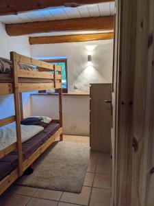 a bedroom with two bunk beds and a bathroom at Rustico Tello in Linescio