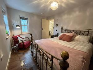 1 dormitorio con 1 cama grande y 1 silla en Secluded Thatched Cottage, near beaches & hill walking, en Rashenny