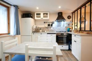 uma cozinha com armários brancos e uma mesa em Casa MaMa&ly em Bellentre
