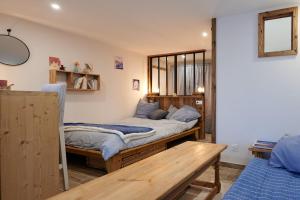 a bedroom with two beds and a wooden table at Casa MaMa&ly in Bellentre