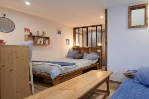 1 Schlafzimmer mit 2 Betten und einem Holztisch in der Unterkunft Casa MaMa&ly in Bellentre