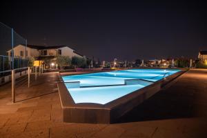 a large blue swimming pool at night at Residence Primera in Moniga