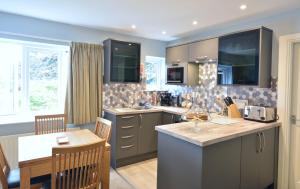a kitchen with a counter and a table in it at Chestnut Apartment in Bowness-on-Windermere