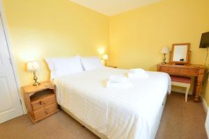 a bedroom with a large white bed with two night stands at Chestnut Apartment in Bowness-on-Windermere