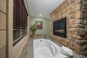 a bathroom with a large tub and a tv at Smoky Pines Chalet - Free Putt-Putt Course! chalet in Gatlinburg