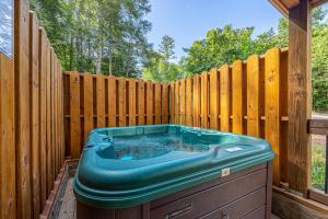 a hot tub sitting next to a wooden fence at Smoky Pines Chalet - Free Putt-Putt Course! chalet in Gatlinburg