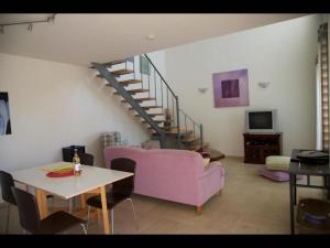 sala de estar con sofá púrpura y escalera en Istron Collection Villas, Villa Selini, en Istron