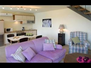 a living room with a purple couch and a kitchen at One bedroom villa with private seawater pool Just 150 meters from the sea in Istron