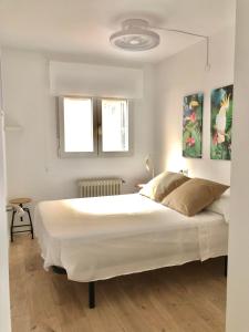 a bedroom with a large white bed and two windows at FLEMING CENTRO in Granada