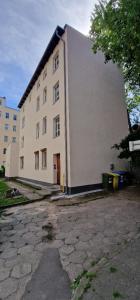 a large white building with a door on the side of it at Apartament Wojciecha 9B 2 - Gdynia Śródmieście 70m2 in Gdynia