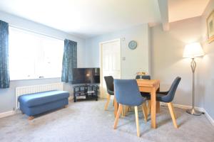 a living room with a table and chairs and a television at Beech Apartment in Bowness-on-Windermere