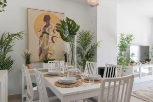 a white dining room with a white table and chairs at ¡Las Brisas en Conchas del Rompido! - El Rompido in El Rompido