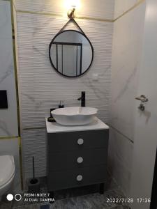 a bathroom with a sink and a mirror at Azzurro Sarafovo in Burgas City