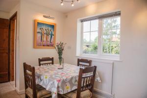 a dining room with a table and a window at Farmhouse Cottage at Mollett's Farm in Saxmundham