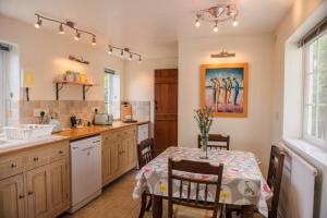 a kitchen with a table and chairs and a sink at Farmhouse Cottage at Mollett's Farm in Saxmundham