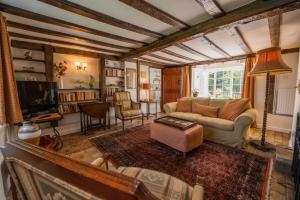 a living room with a couch and a tv at Farmhouse Cottage at Mollett's Farm in Saxmundham