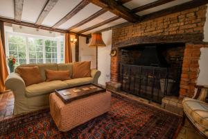 a living room with a couch and a fireplace at Farmhouse Cottage at Mollett's Farm in Saxmundham