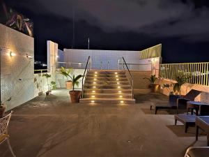un conjunto de escaleras con luces en un patio por la noche en Hotel 12 BEES by Kavia, en Playa del Carmen