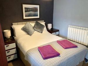 a bedroom with a bed with two towels on it at Briscoe Lodge Self Catering Apartments in Windermere