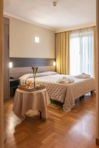 a bedroom with two beds and a table with flowers on it at Grande Albergo in Sestri Levante
