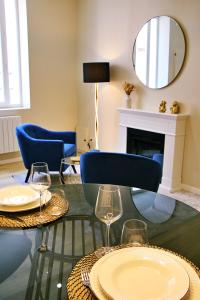 a living room with two tables with wine glasses and a fireplace at Appartement luxueux avec Jacuzzi privatif in Roanne