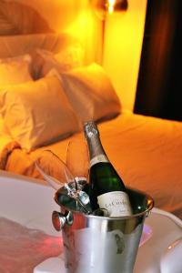Una botella de champán en un cubo sobre una mesa en Appartement luxueux avec Jacuzzi privatif en Roanne