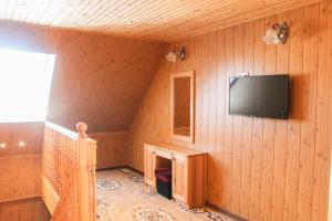 um quarto com uma televisão numa parede de madeira em Käopesa Kodumajutus em Põlva