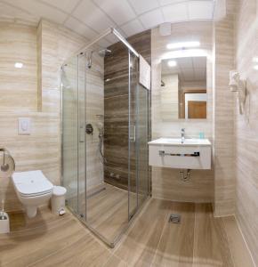 a bathroom with a shower and a toilet and a sink at Lago Hotel in Ohrid