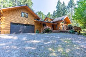 a wooden house with a garage and a driveway at Northwoods Dream Retreat in Whitefish