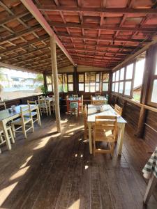 a restaurant with tables and chairs on a wooden floor at Pousada Canoa Beach in Canoa Quebrada