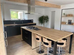 eine Küche mit einer Holzterrasse mit einer Arbeitsplatte in der Unterkunft Belle maison avec grand jardin proche St Malo in Miniac-Morvan