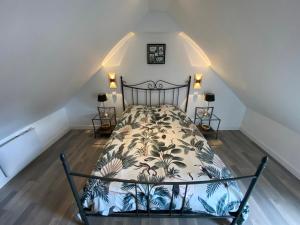 ein Schlafzimmer mit einem Bett im Dachgeschoss in der Unterkunft Belle maison avec grand jardin proche St Malo in Miniac-Morvan