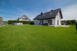 a house with a large yard with green grass at Dom Marina in Mosty