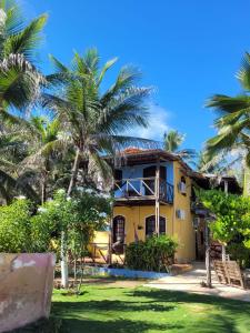 a house with palm trees in front of it at Pousada Canoa Beach in Canoa Quebrada