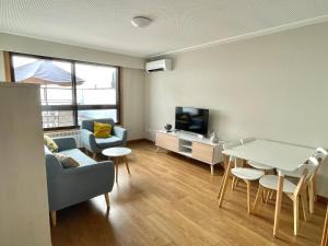 a living room with a table and a tv at Estudio céntrico 1 con terraza y parking privado in Ourense