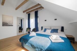 sypialnia z niebieskim łóżkiem z niebieską i białą pościelą w obiekcie Dom Marina w mieście Mosty