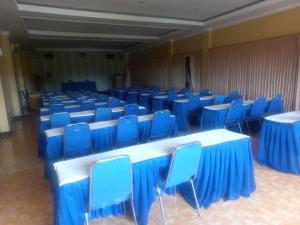 a room with blue chairs and tables and blue tables and chairs at Collection O 91489 Hotel Tanjung Permata in Cilacap