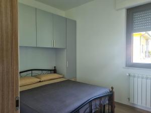 sypialnia z łóżkiem z szafką i oknem w obiekcie La dolce vita w mieście Scanzano